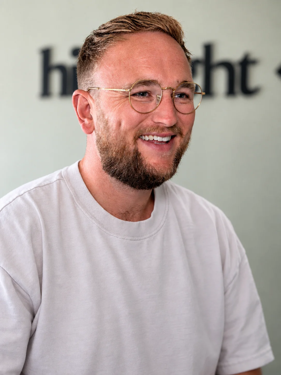 Tom Hines smiling in a white T-shirt